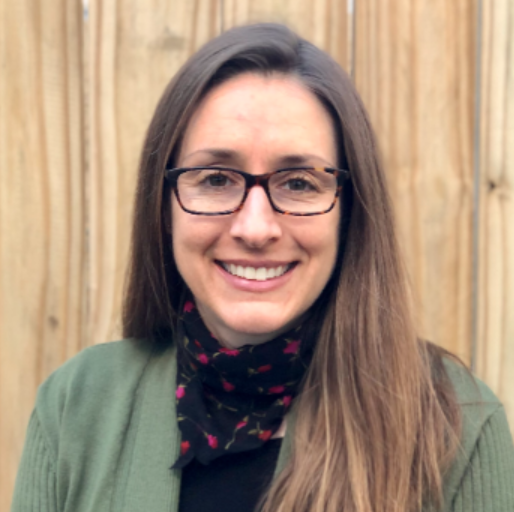 This is a portrait of Prof. Cynthia Gordon. She is a white woman with straight, light brown hair, wearing square glasses,  a black short, sage green jacket, and a floral black and red scarf. 