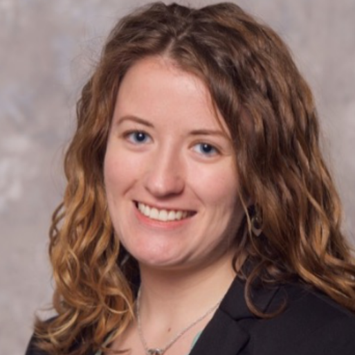 Prof. Heidi Getz is a white woman with blue eyes and blonde curly hair. She is wearing a black shirt and a silver necklace. 