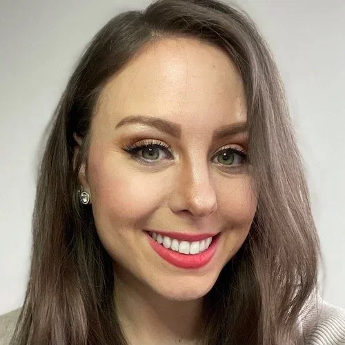 Headshot of Kris Cook with shoulder-length brown hair, smiling against a neutral background